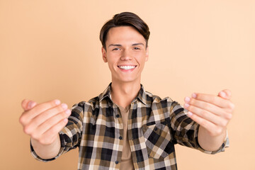 Photo of young cute guy come wear checkered shirt isolated on beige color background