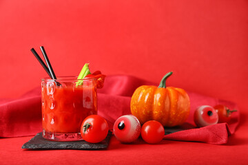 Glass of tasty bloody Mary cocktail decorated for Halloween on color background