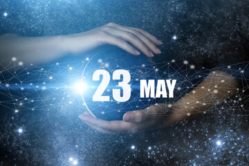 May 23rd. Day 23 of month, Calendar date. Human holding in hands earth globe planet with calendar day. Elements of this image furnished by NASA. Spring month, day of the year concept.