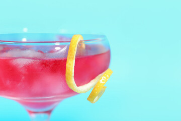 Glass of tasty cosmopolitan cocktail on color background, closeup