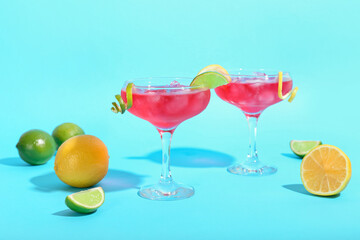 Glasses of tasty cosmopolitan cocktail on color background