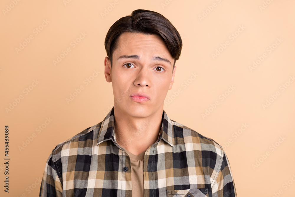 Sticker photo of millennial unsure guy wear checkered shirt isolated on beige color background