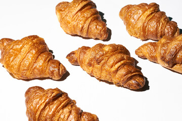 Croissant pattern with hard light on a white background. Many different croissants