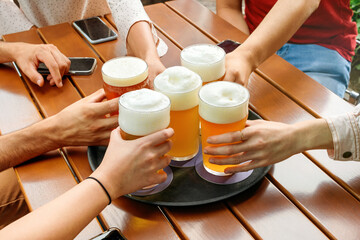 Friends with beer glasses at table