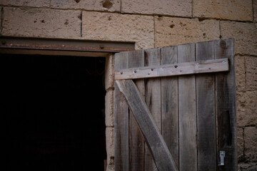 Une vieille porte en bois ouverte sur une grange