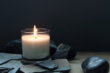 the burning luxury aromatic scented candle glass on the wooden table with background of vintage...