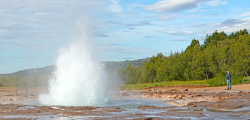Geysir, Iceland - July 28, 2021: Geyser Strokkur in iceland errupting with hot water and steam, each year many tourists visit the geyser located in the golden circle