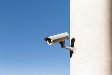 Modern security camera against cloudless sky.