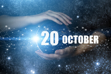 October 20th. Day 20 of month, Calendar date. Human holding in hands earth globe planet with...
