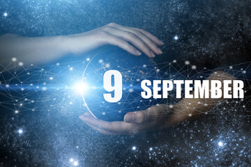 September 9th. Day 9 of month, Calendar date. Human holding in hands earth globe planet with...