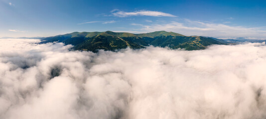 Aerial panorama of a mountain range above the clouds