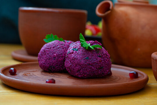 delicious appetizing Georgian dish phali made of beetroot on a clay plate on the background of national Georgian pottery