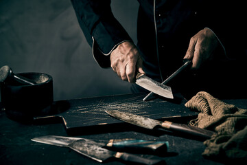 Chef sharpening his knife with an old fashioned metal file