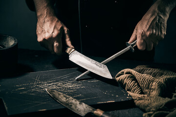 Chef sharpening the blade of a large knife on a file