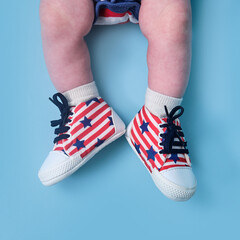 A newborn baby shoes in the colors of the American flag of the United States, blue studio...