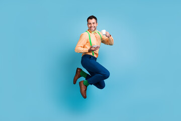Obraz premium Photo of british guy jump hold cup drink tea wear suspenders shirt pants shoes isolated blue color background