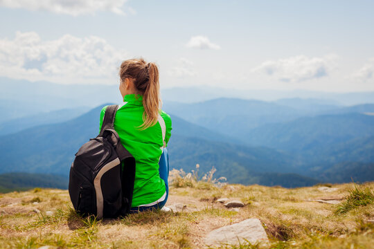 Trip to Carpathian mountains. Happy woman tourist hiker resting on top of Hoverla. Traveling in summer Ukraine