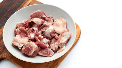 Raw pork ribs in white plate on wooden cutting board