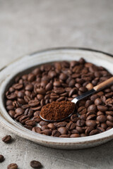 Coffee beans on a plate. A spoon with ground coffee. Arabica. Macro photography in food photography.