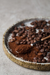 Coffee beans on a plate. A spoon with ground coffee. Arabica. Macro photography in food photography.