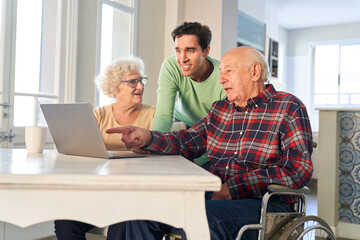 Sohn hilft Senioren Eltern am Computer beim Video Streaming