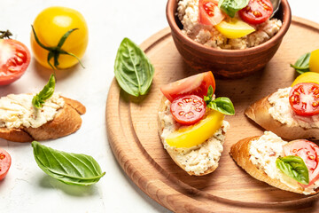 Italian tomato and cheese bruschetta. Tapas, antipasti with chopped vegetables, herbs and oil on grilled baguette bread.