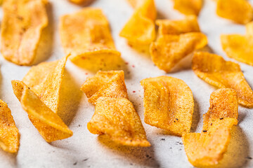 Spicy banana chips on gray background. Indian food concept.