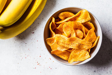 Spicy banana chips on gray background. Indian food concept.