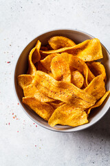 Spicy banana chips on gray background. Indian food concept.