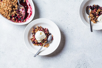 Berry crumble pie with scoop of ice cream, gray background.
