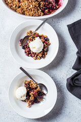 Berry crumble pie with scoop of ice cream, gray background.