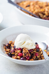 Berry crumble pie with scoop of ice cream, gray background.
