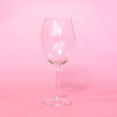 broken wine glass with shards on pink background