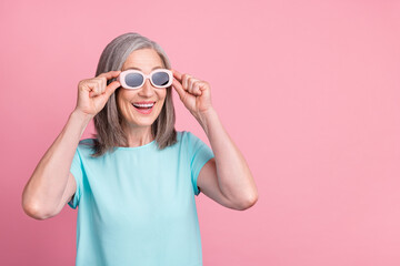 Photo of impresed old white hair lady look empty space wear spectacles teal blouse isolated on pink color background