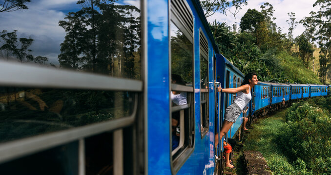 A tourist travels by train to beautiful places, a panorama. A beautiful woman travels by train around the world. Travel by train in Sri Lanka. A traveler in Sri Lanka. Railway transport. Copy Space