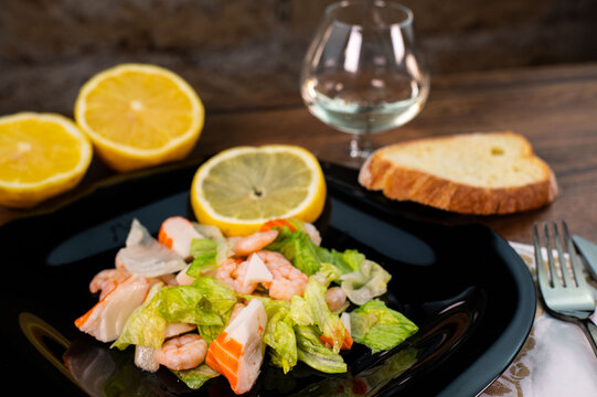 composition of a black plate with shrimp and surimi salad
