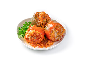 Three peppers stuffed with turkey, rice and vegetables with fresh herbs isolated on a white background.