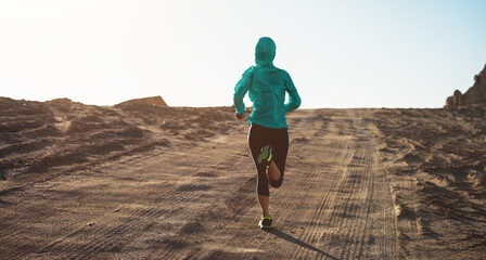 Fitness woman trail runner cross country running  on sand desert
