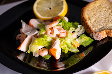 composition of a black plate with shrimp and surimi salad