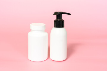 jar for vitamins or dietary supplements and pump bottle mockup pink background. Natural skincare beauty product. Branding and packaging presentation.