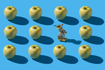 a pattern of green apples on a blue background with one rot in the middle