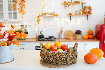 colorful autumn still-life on a kitchen table. Pumpkin, bouquet of maple leaves and apples