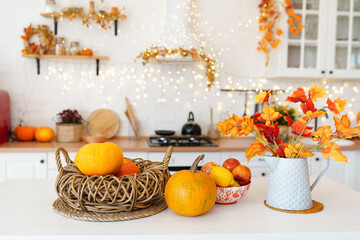 colorful autumn still-life on a kitchen table. Pumpkin, bouquet of maple leaves and apples