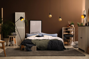 Stylish room interior with large bed near brown wall