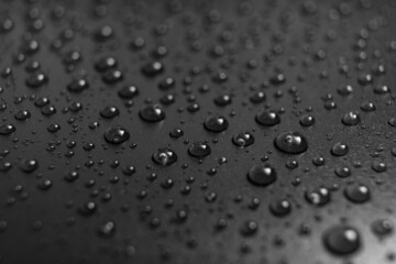 drops of water on a black background. texture. dew on the surface. moistening. drops after rain or fog.
