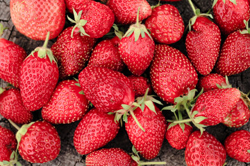 Heap of strawberries on natural wooden background. New fresh harvest, summer, summertime, garden concept. Organic gresh natural diet eco friendly food. 