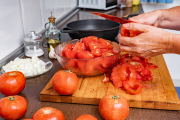 Hands removing the peel from the red tomato