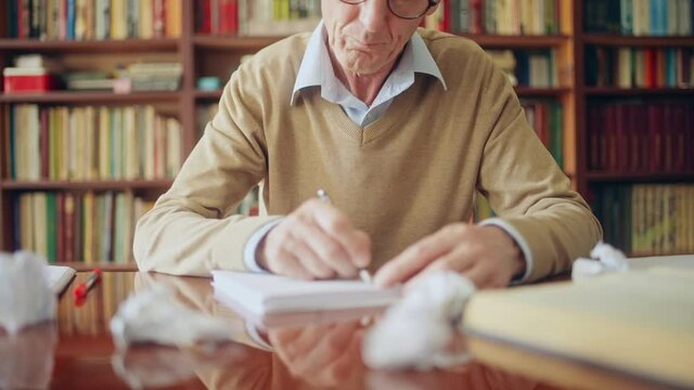 Annoyed senior writer writing down ideas, crumpling paper, lack of inspiration