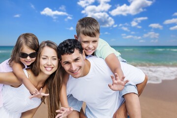 Happy young family of four on the beach vacation