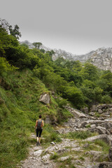 woman trekking to the source of the nervion in the province of vizcaya through a green valley